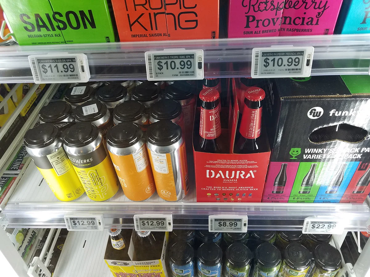 Retail cooler display with assorted craft beer cans, bottles, and variety packs