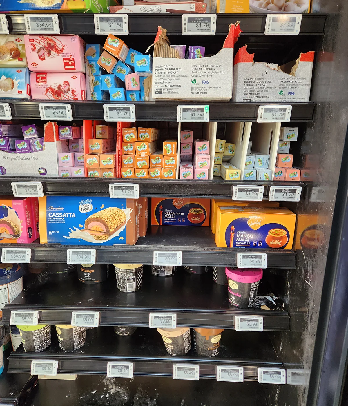 Supermarket shelf with electronic price display and packaged grocery products in retail store