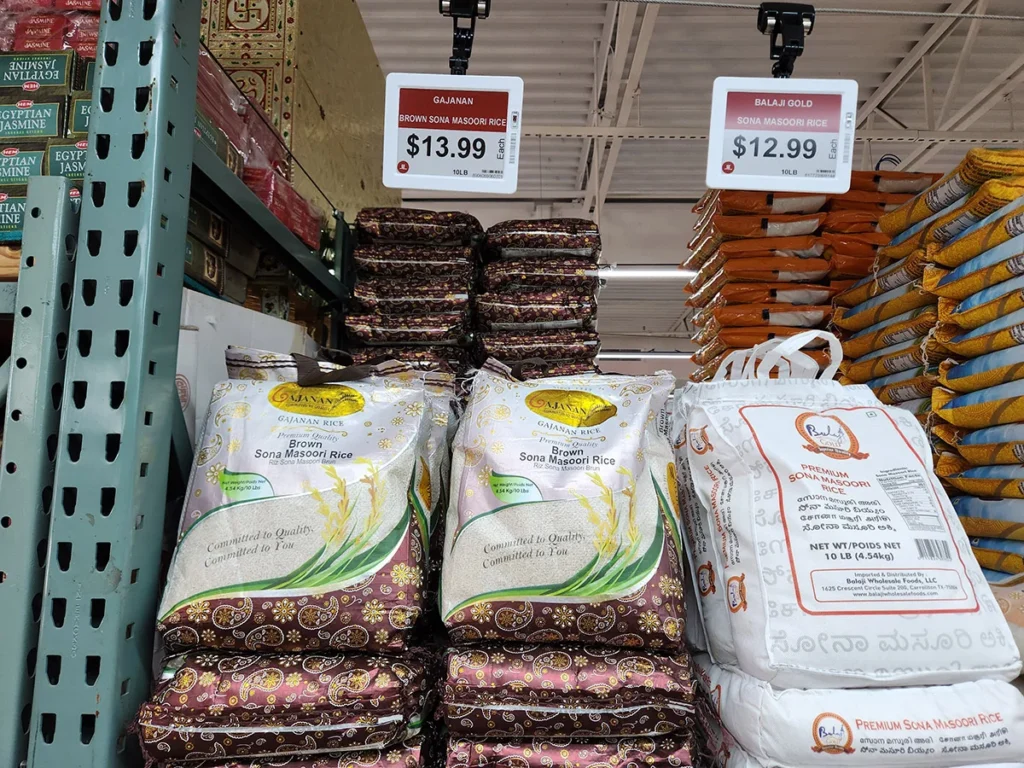Supermarket shelf featuring brown and premium Sona Masoori rice packages