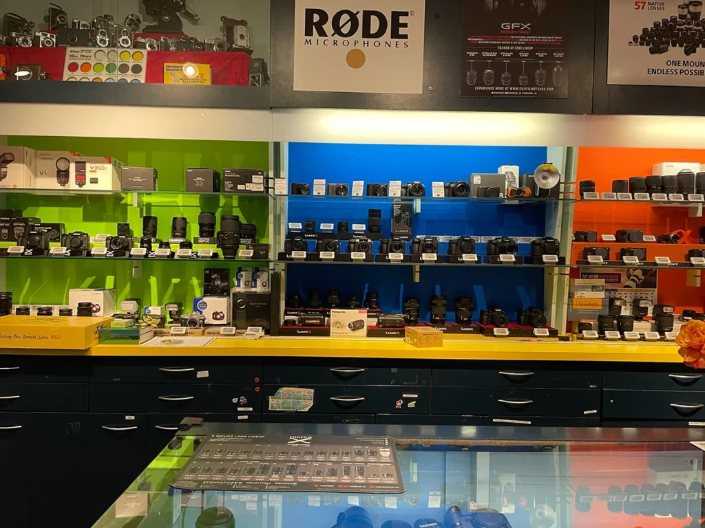 Camera shop display with lenses and photography equipment arranged on retail shelves